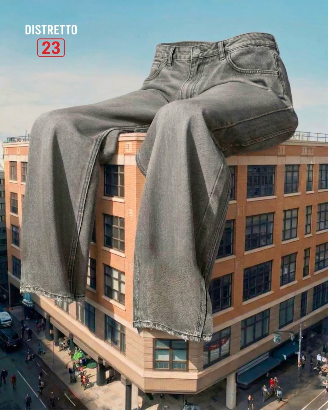 Jeans grigi giganti seduti sul tetto di un palazzo in mattoni sopra una strada trafficata, con il logo Distretto 23