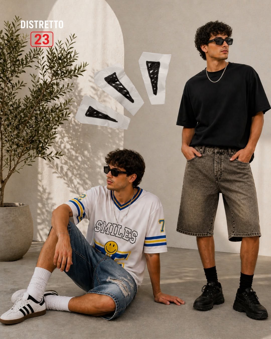 Due ragazzi con occhiali scuri in bermuda denim, jersey bianca SMILES e t-shirt nera oversize, logo Distretto 23